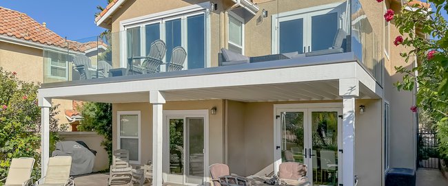 Exterior view of Dana Point residence's newly extended deck and new French doors on the first and second levels.