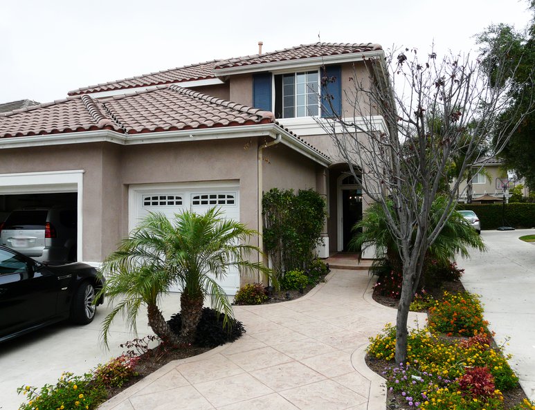 An image of the exterior of an Irvine home before the third car garage was converted into additional indoor living space.